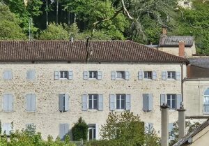 Maison dite maison bourgeoise photographiée à Jujurieux en 2024, avec sa façade aux 27 fenêtres et son orangerie accolée sur la droite.